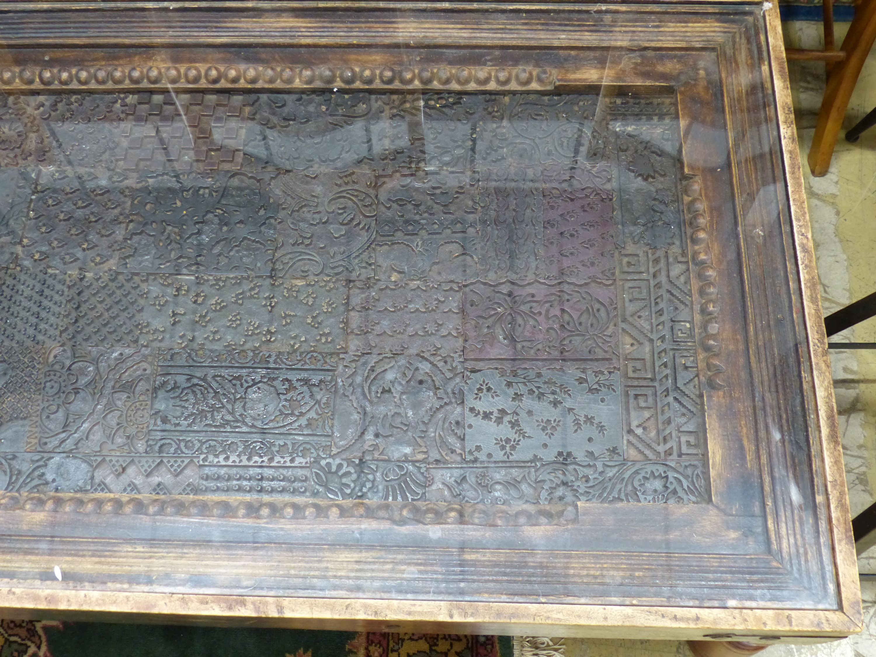 An Indian hardwood coffee table inset with a printing block, length 140cm, width 80cm